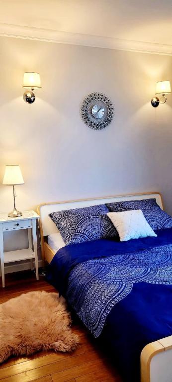 a bedroom with a blue bed and two lamps and a rug at HomeComfort Atlantic Room in Warsaw