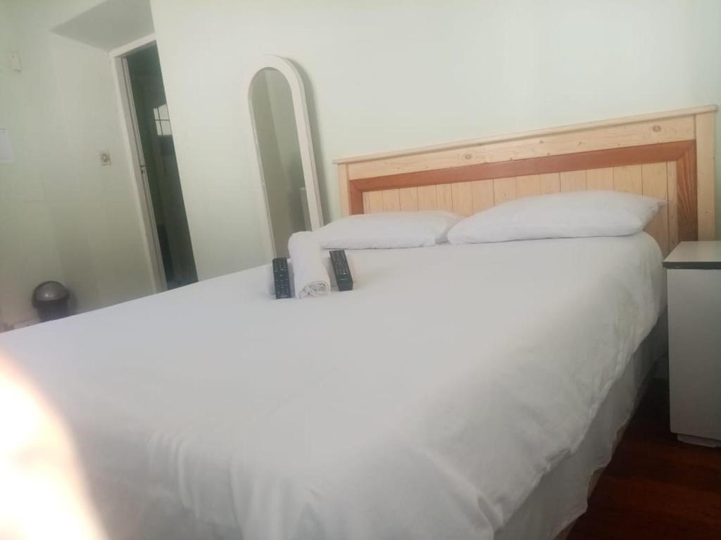 a bed with white sheets and pillows in a room at Lisokhanya GuestHouse in East London