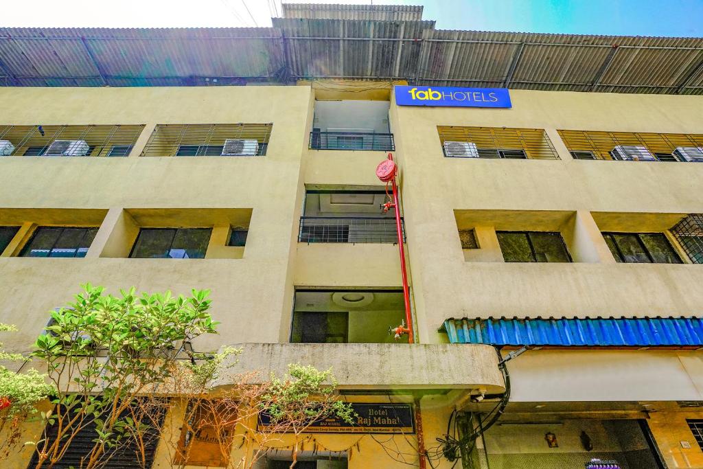 un bâtiment avec un panneau sur son côté dans l'établissement FabExpress Rajmahal, à Navi Mumbai