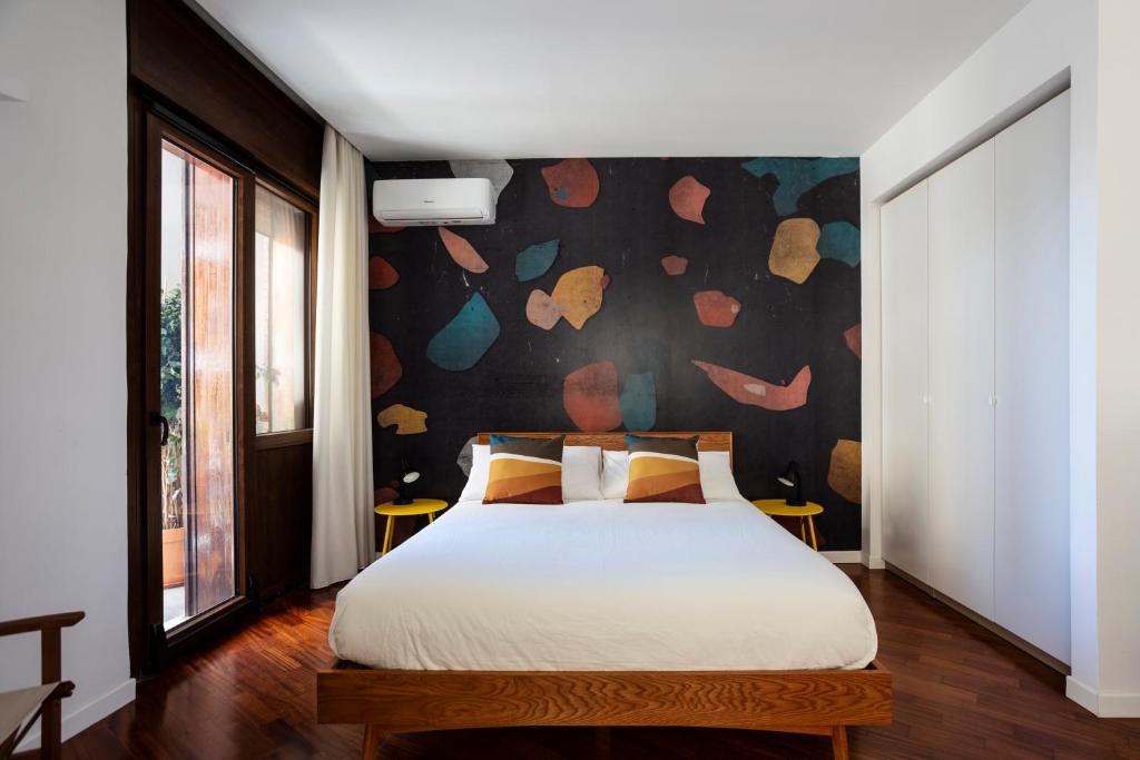 a bedroom with a bed with a floral wall at Casa Cervantes in Naples