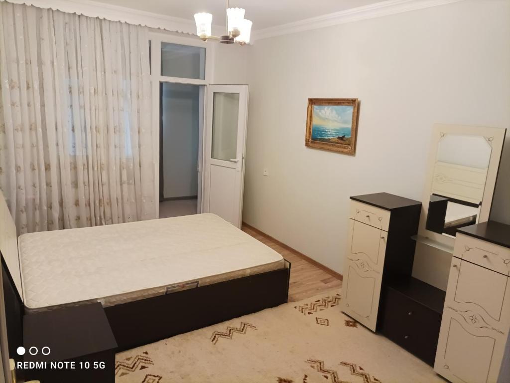 Schlafzimmer mit einem Bett, einer Kommode und einem Spiegel in der Unterkunft Nakhchivan Center in Nachitschewan