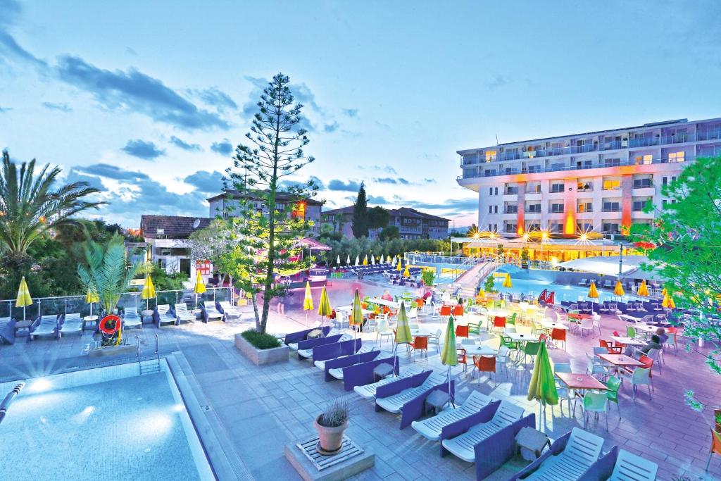 un complejo con piscina, sillas y un edificio en Numa Konaktepe Hotel, en Konaklı