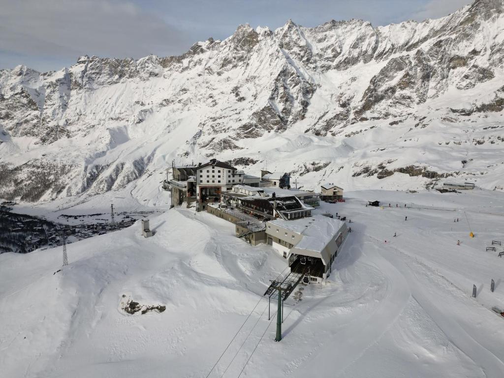 domek narciarski w śniegu z górą w obiekcie Hotel lo Stambecco w mieście Breuil-Cervinia