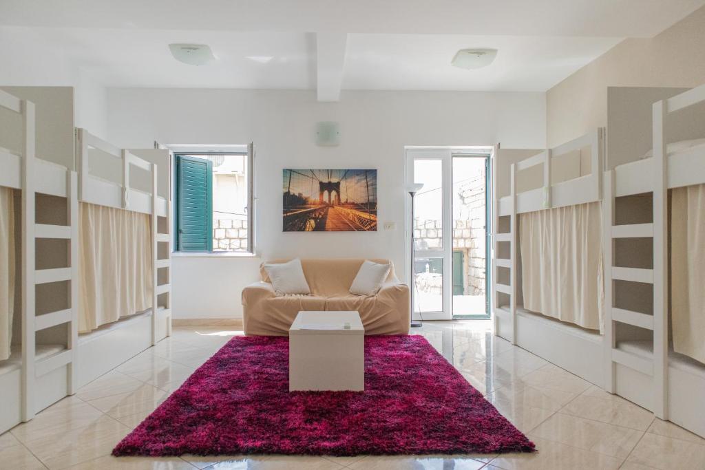 a living room with a couch and a red rug at Love Dubrovnik Hostel in Dubrovnik