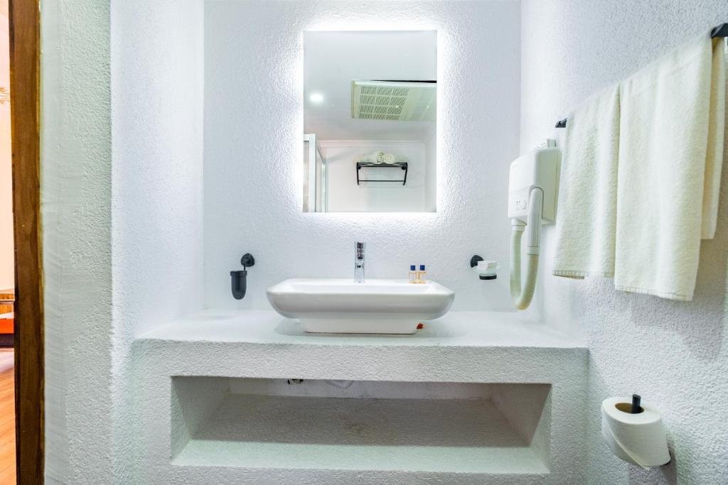 a white bathroom with a sink and a mirror at Costa Bitezhan Hotel - All Inclusive in Bitez