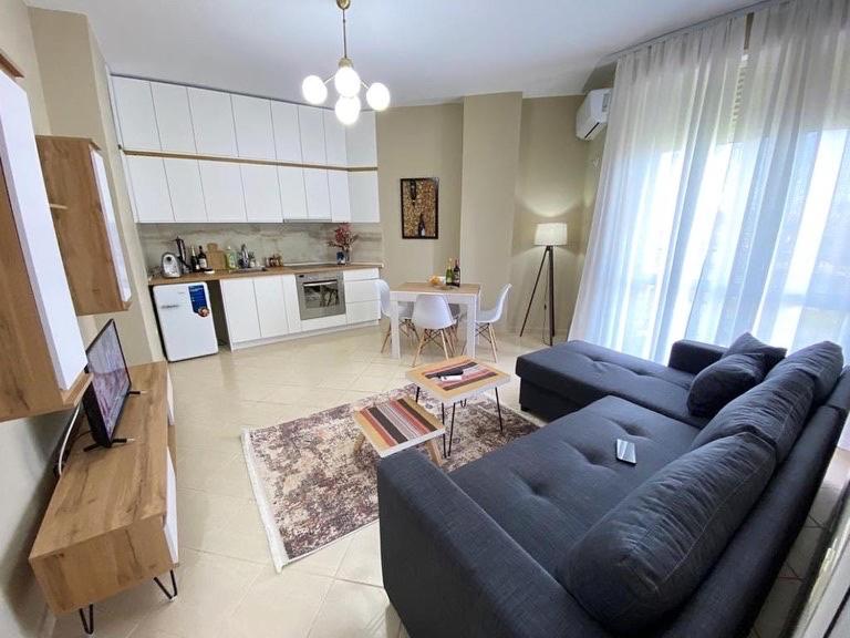 ein Wohnzimmer mit einem blauen Sofa und einer Küche in der Unterkunft AROL Apartment, Golem in Golem