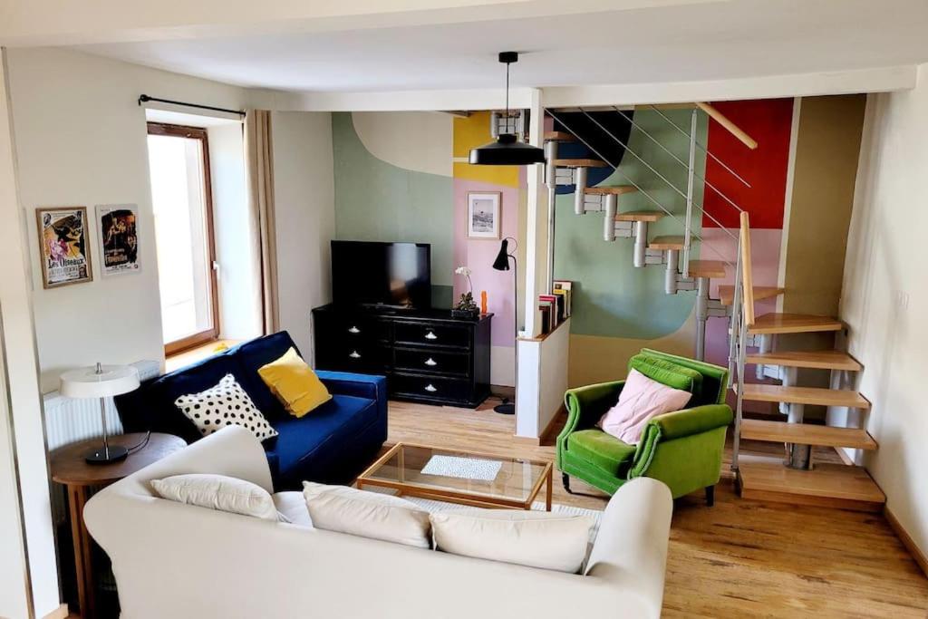 a living room with a couch and a staircase at Maison de village rénovée in Metz