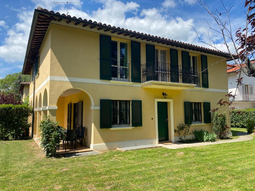 Casa amarilla con persianas verdes y patio en Casa di totto, en San Giovanni Di Baiano