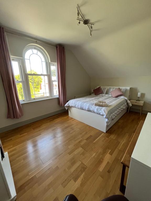 a bedroom with a bed and a large window at clover cottage in Kinsale