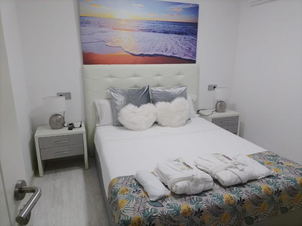 a bedroom with a bed with white sheets and pillows at Casa A Boleriña 2 in Combarro