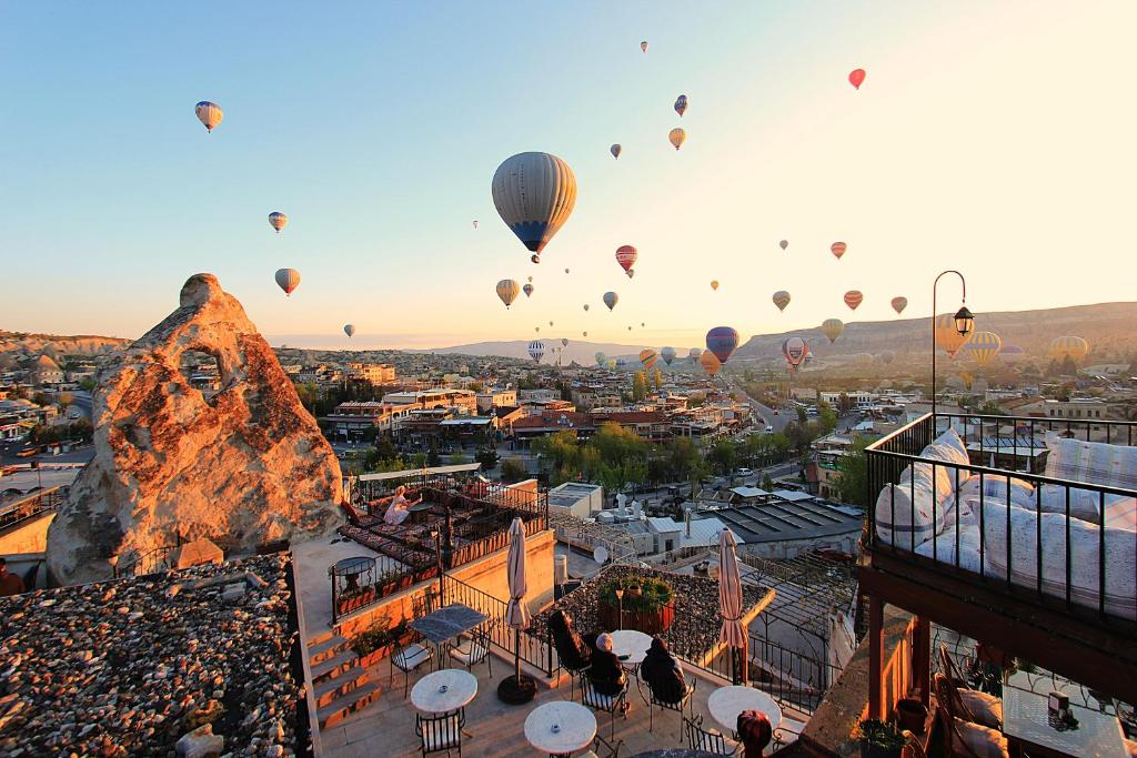 a group of hot air balloons flying over a city at Bedrock Cave Hotel in Goreme