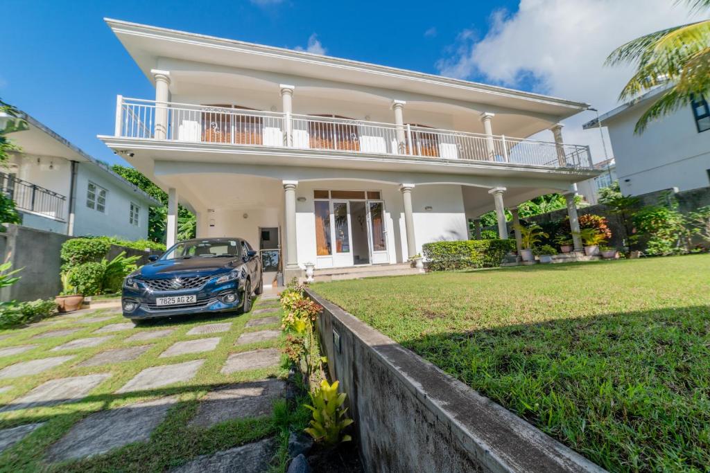 a car parked in front of a house at Tropicana Villa in Le Morne