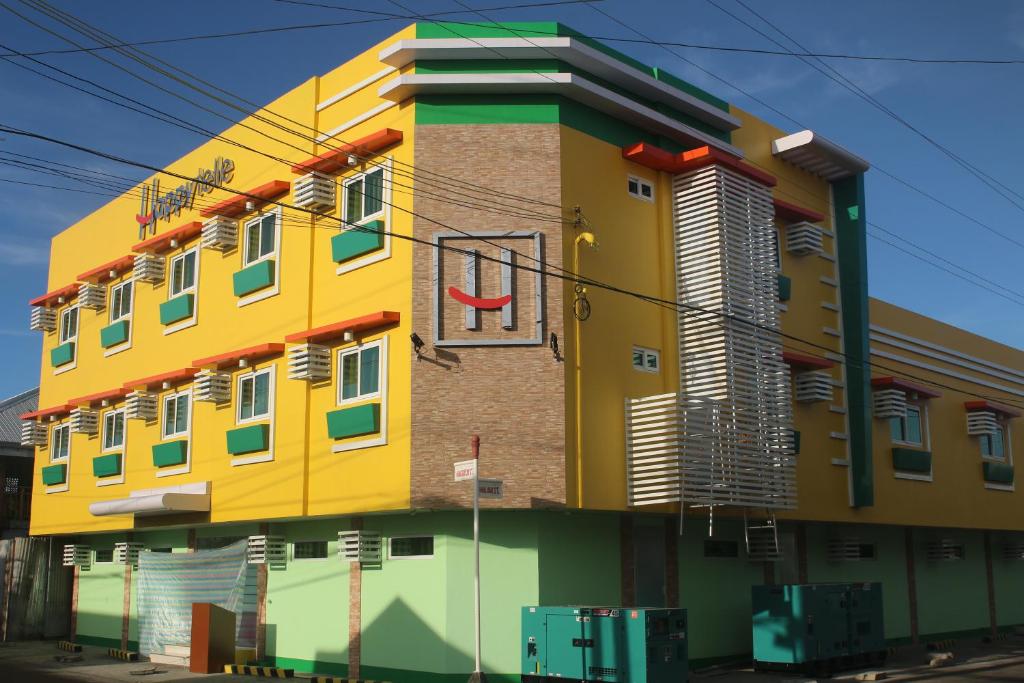 ein gelbes und grünes Gebäude an der Straßenseite in der Unterkunft Happytelle in Dipolog City