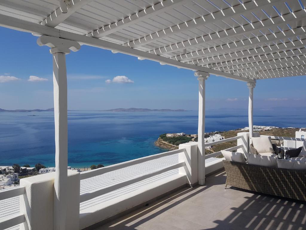 a white pergola on a house with the ocean at Panoramic View Mykonos in Mýkonos City