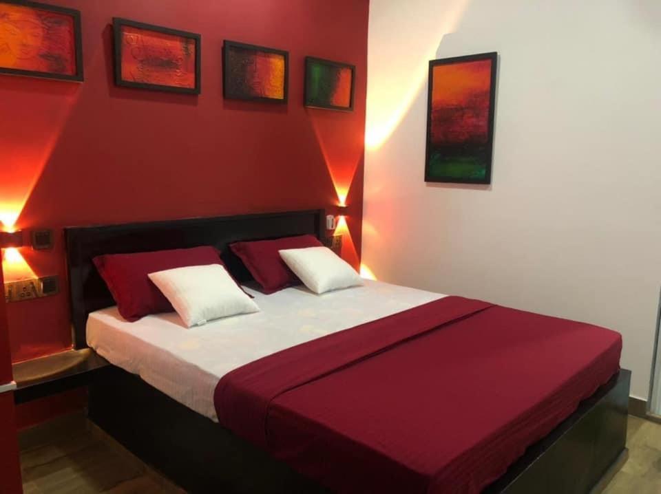 een slaapkamer met een groot bed met rode muren bij Saga Homestay in Kurundankulama