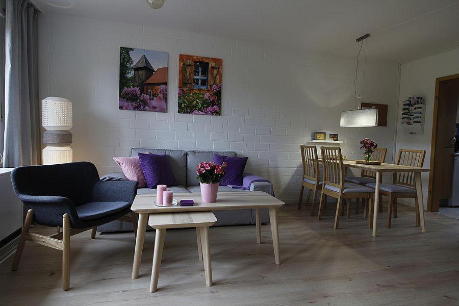 ein Wohnzimmer mit einem Sofa, Tischen und Stühlen in der Unterkunft Ferienhaus Waldburg in Müden