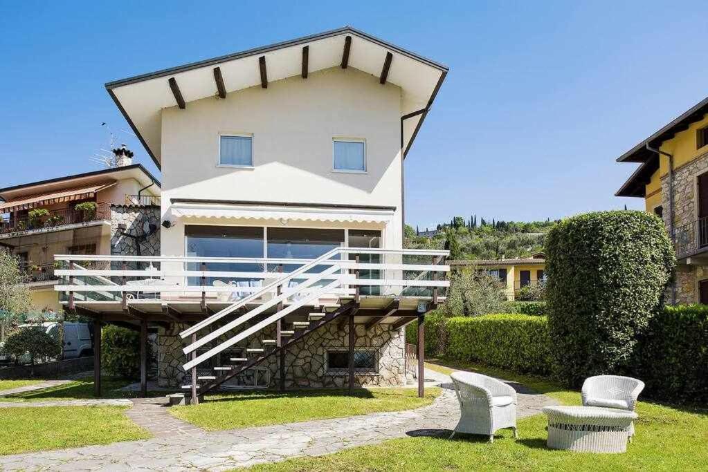 a large house with a staircase in front of it at Villa Gardesana Torri del Benaco in Torri del Benaco