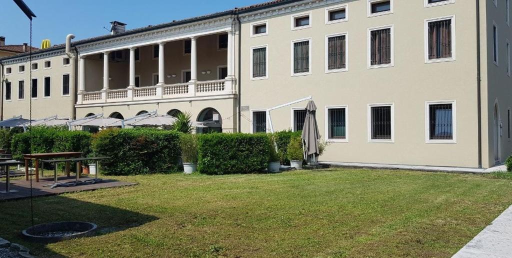 a large white building with a grass yard at La Loggia Vicenza in Vicenza