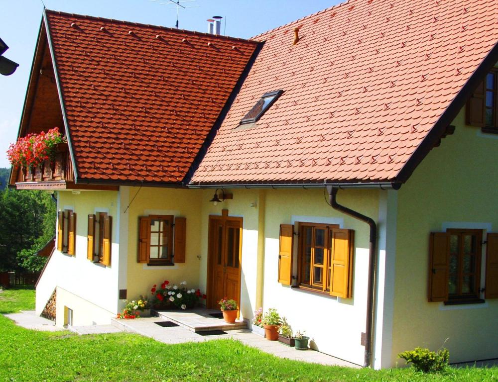 ein weißes Haus mit rotem Dach und einigen Pflanzen in der Unterkunft Ferienhaus Eichberg in Leutschach