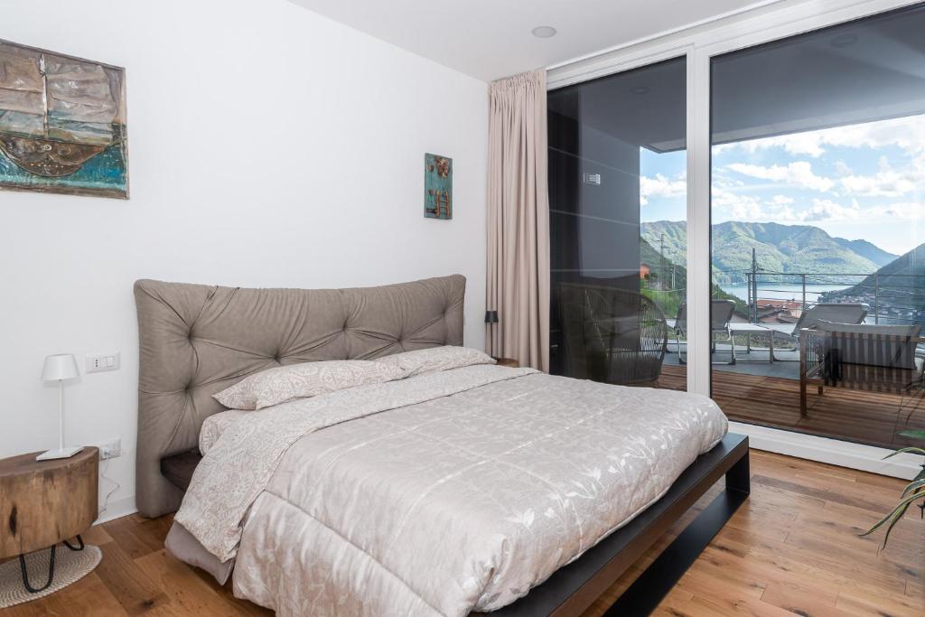 - une chambre avec un lit et une grande fenêtre dans l'établissement Appartamento Dany con vista lago, à Nesso
