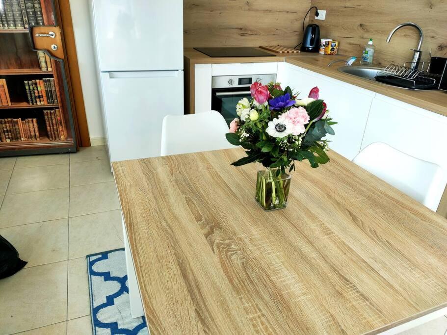 un vase de fleurs assis sur une table dans une cuisine dans l'établissement Grand F2 Bastia, Port de Toga, Terrasse Vue Mer, à Bastia