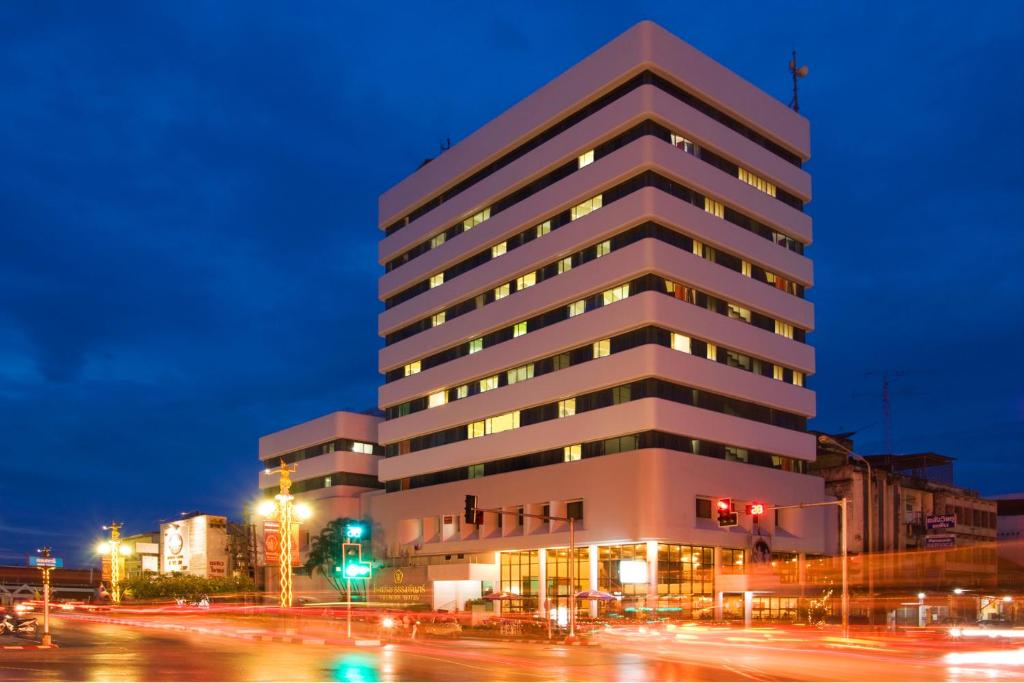 un edificio alto en una calle de la ciudad por la noche en Thumrin Hotel, en Trang