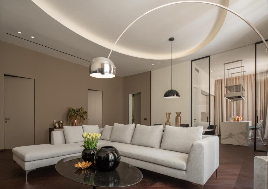 a living room with a white couch and a table at Sant'Ambrogio Luxury Apartment R&R in Milan