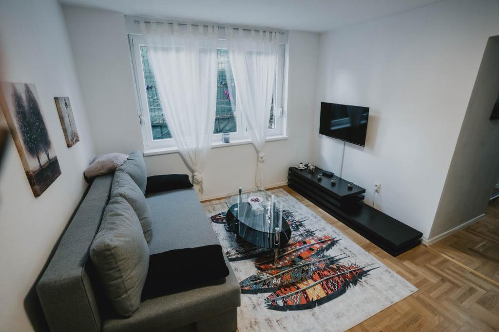 uma sala de estar com um sofá e uma televisão em Apartman Daris 2 em Sarajevo