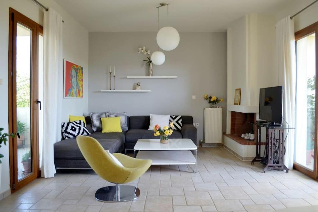 un soggiorno con divano e sedia gialla di Elektra Apartment-Kallithea a Calitea (Kallithea)