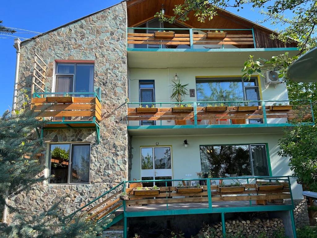 una casa con balcones de madera en un lateral en Green Stone Boutique Hotel, en Yeghegnadzor