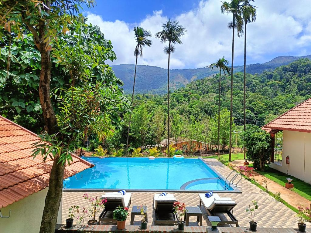 a swimming pool in a resort with palm trees at Hill Crest Resort - Coorg in Madikeri
