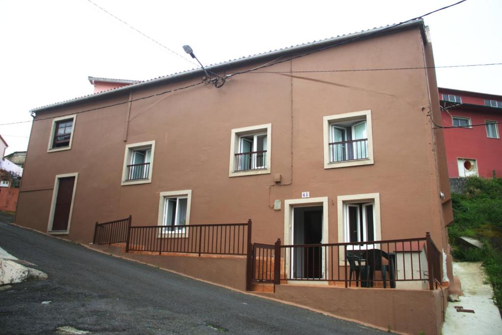 uma casa castanha com janelas brancas e uma rua em Casa da Castañuela em Muros