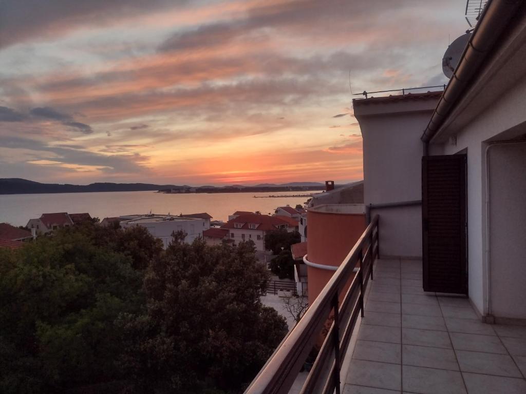 a view of a sunset from the balcony of a house at Apartment Tomi in Brodarica