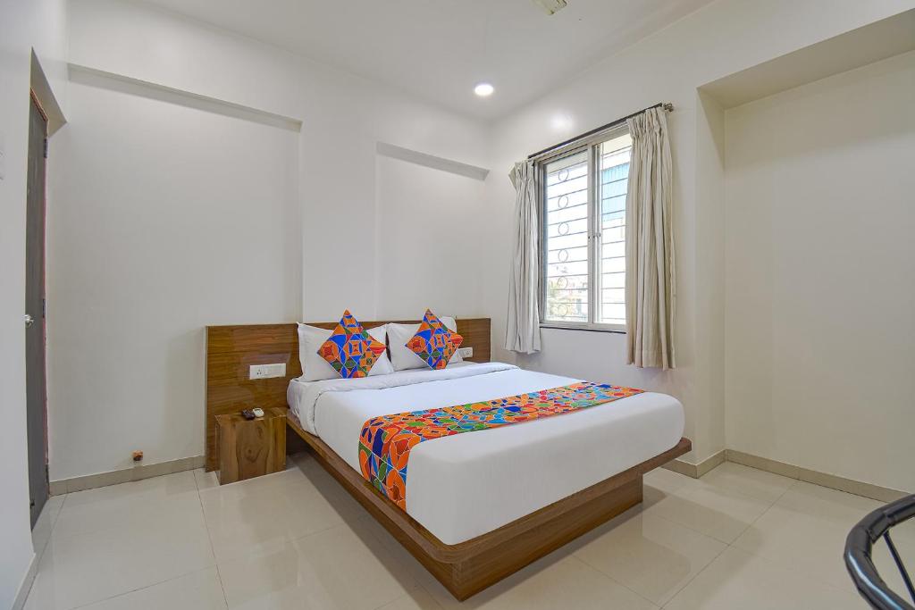een slaapkamer met een groot bed en een raam bij FabHotel Skylight Studio Rooms in Pune