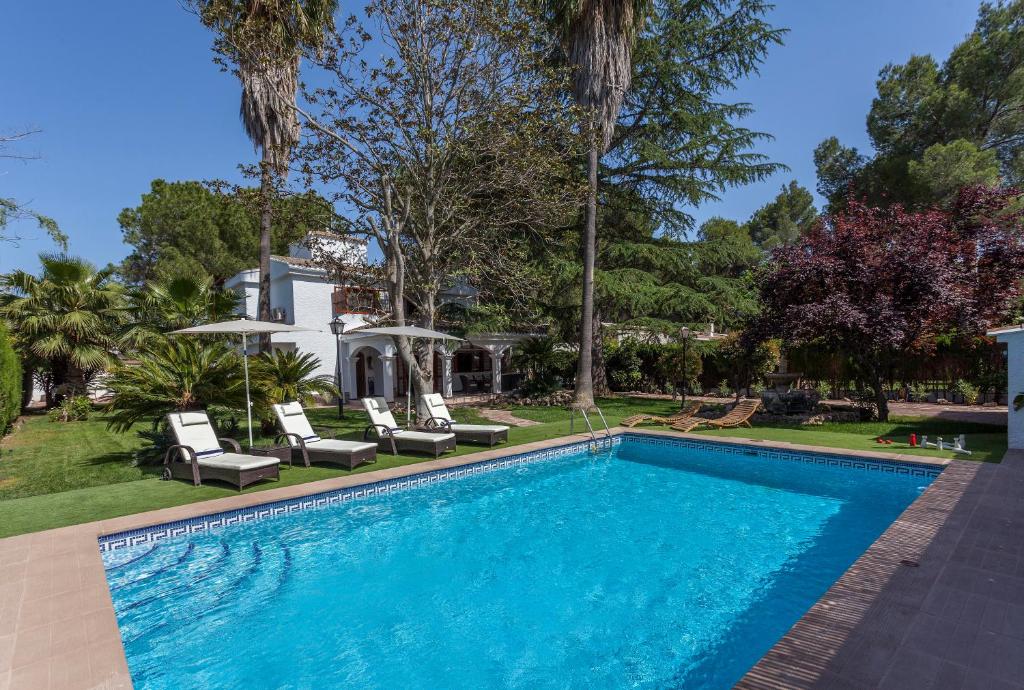 a swimming pool with chairs and a house at VILLA LATEL in Serra