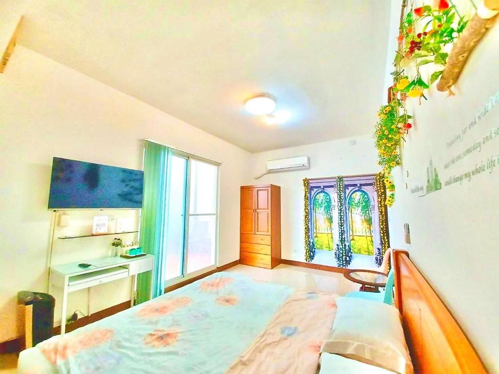 una camera con letto, scrivania e finestra di Lohas-artist B&B a Chaozhou