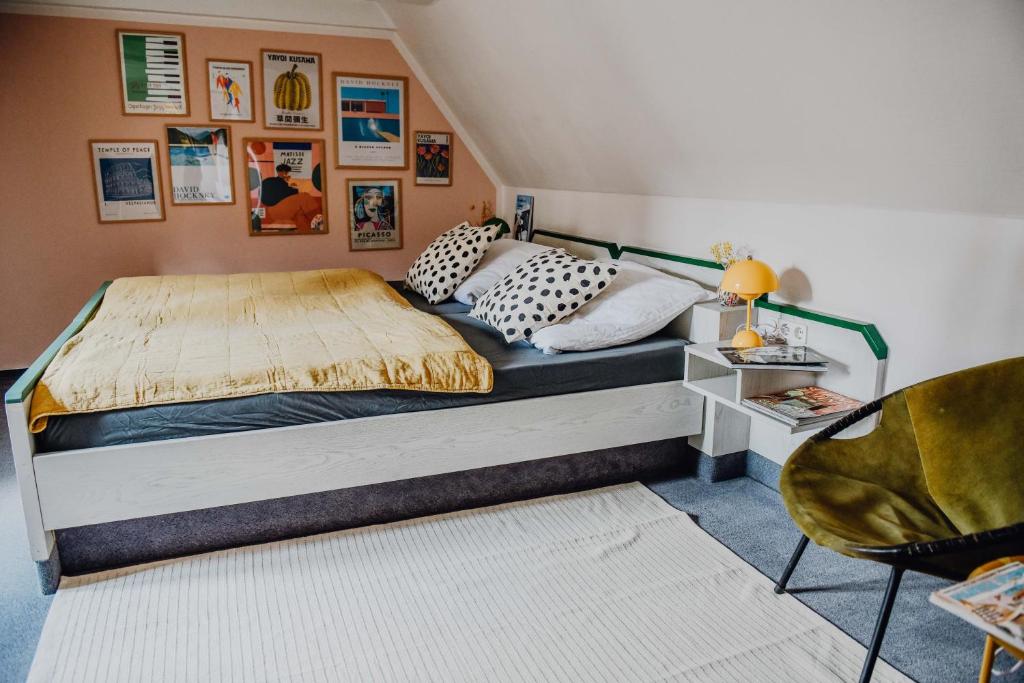 1 dormitorio con 1 cama grande y 1 silla en sleepArt room for 3 en Celle