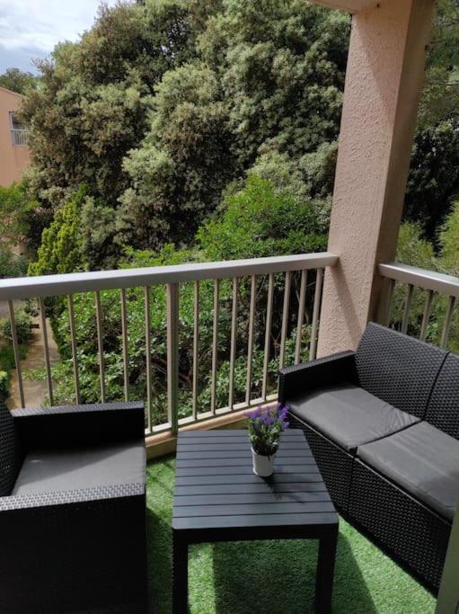 a porch with a bench and a table on a balcony at Charmant studio climatisé 24 m2 terrasse à 100m de la plage in Saint-Mandrier-sur-Mer