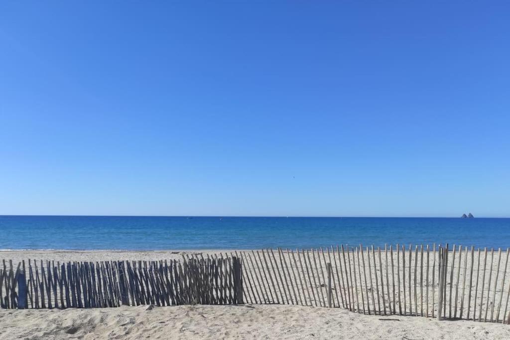 a fence on the beach with the ocean in the background at Charmant studio climatisé 24 m2 terrasse à 100m de la plage in Saint-Mandrier-sur-Mer