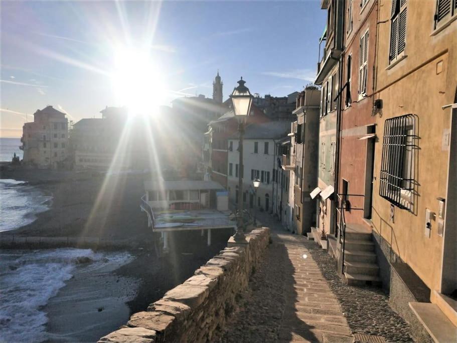 un sole che splende su una strada con edifici e una spiaggia di Bogliasco a due passi dal mare a Bogliasco
