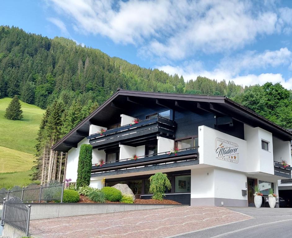 a large building with a mountain in the background at Alpenpension Maderer in Gaschurn