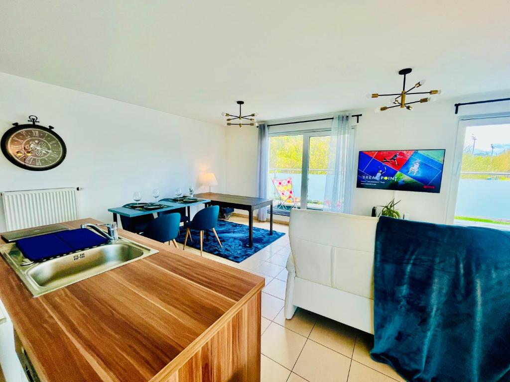 a kitchen and living room with a sink and a table at Luxembourg City - 70m2 - Easy parking - Bus - 2 TVs - between City and Forest in Luxembourg