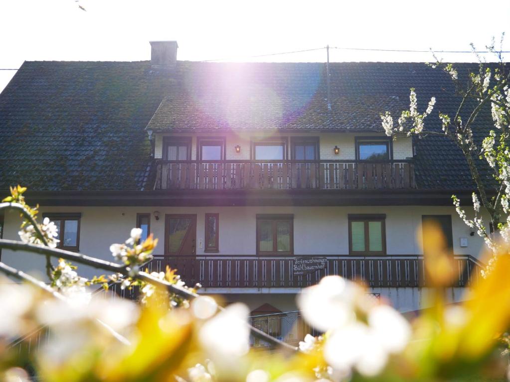 uma grande casa branca com uma varanda em Bühlbauernhof em Bad Peterstal-Griesbach