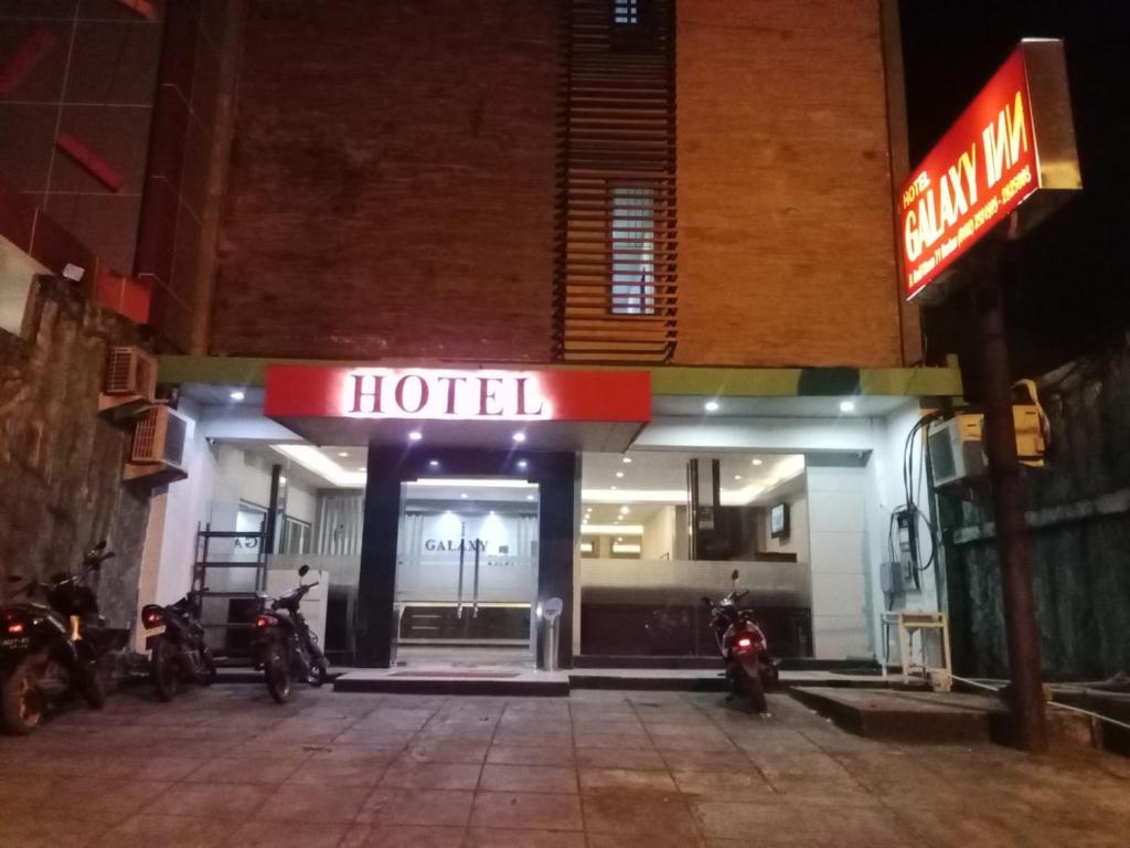 hotel z motocyklami zaparkowanymi przed nim w nocy w obiekcie Galaxy Inn w mieście Baubau