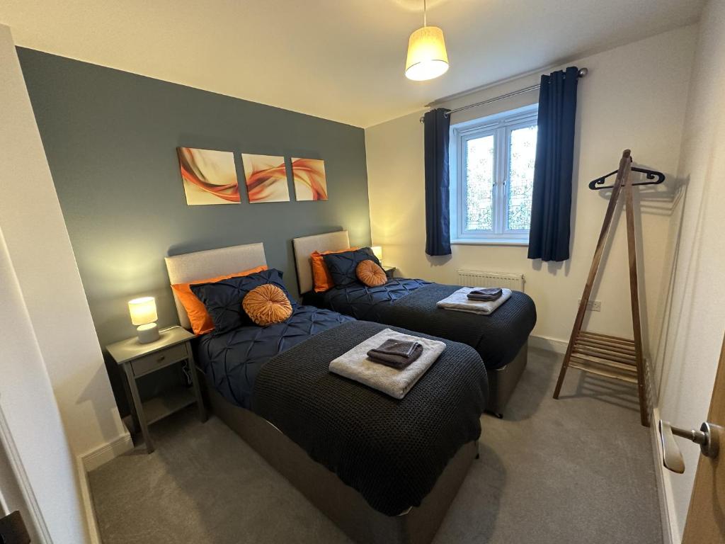 a bedroom with a bed and a bed and a window at 3 Bed Home Sleeps 6 - Long Stays - Contractors & Relocators with Parking, Garden & WiFi in Milton Keynes
