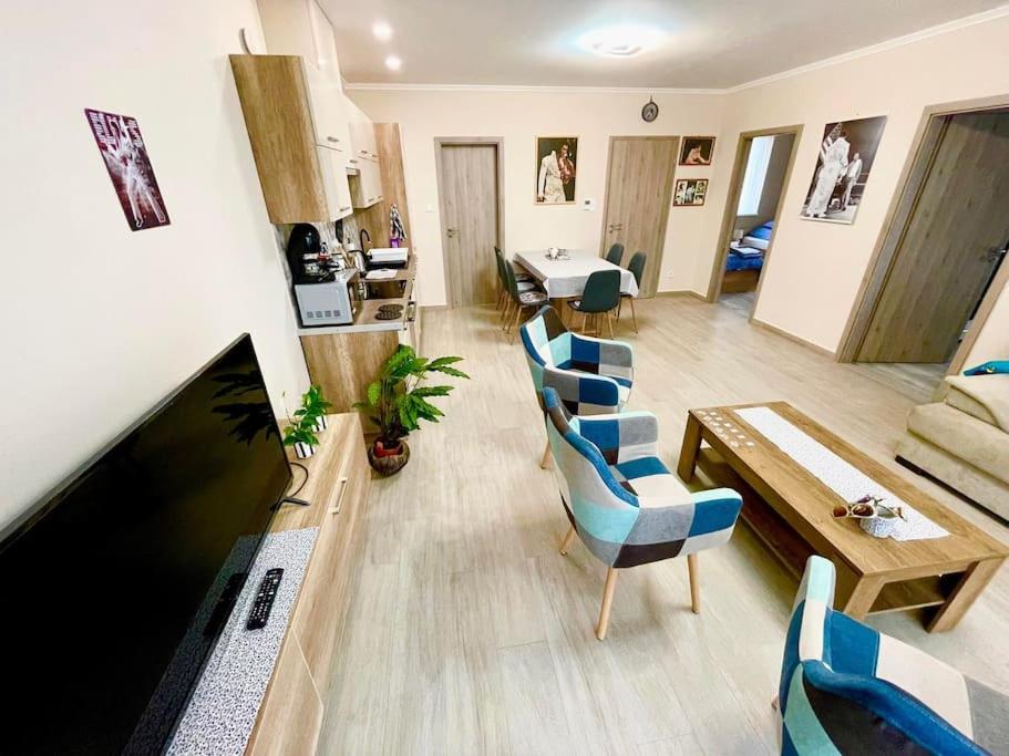 sala de estar con sillas azules y mesa en ELVIS Apartman, en Pápa