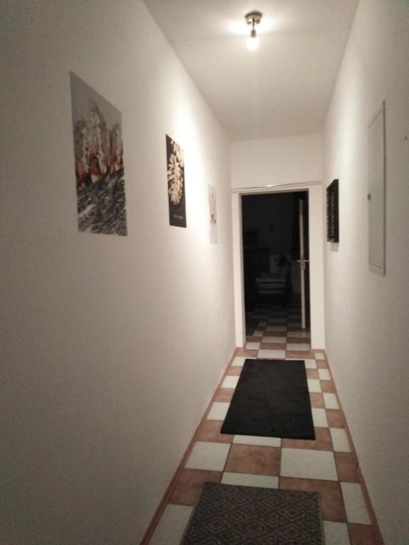 a hallway with pictures on the wall and a floor with rugs at Studiowohnung, Neu renoviert, zentrale Lage in Saarlouis