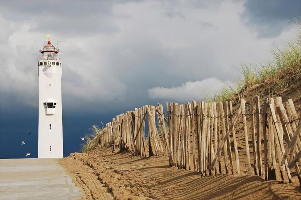 a lighthouse on the beach next to a fence at Voilà! - beach at 500m- free parking in Noordwijk aan Zee