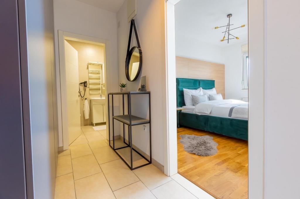 Schlafzimmer mit einem Bett und einem Spiegel in der Unterkunft Platinum_Luxury_Apartment in Teslić