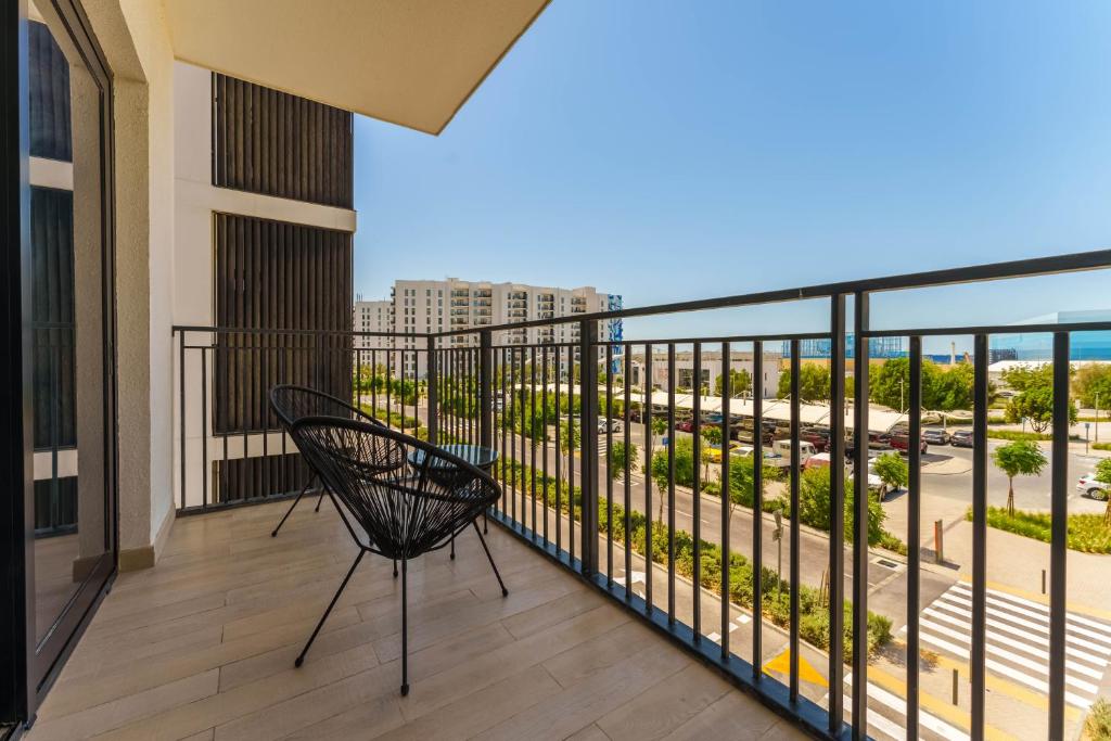 einen Balkon mit einem Stuhl und Meerblick in der Unterkunft Maison Privee - Exquisite Apt on Yas Island cls to ALL attractions in Abu Dhabi